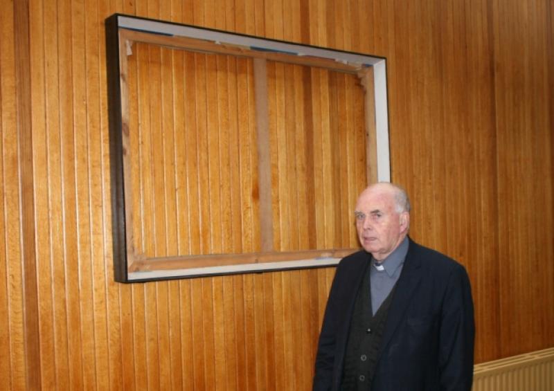 Stripped bare:  Fr Tom Ryan stands in front of one the frames where the paintings were cut out with a stanley knife, in the Holy Rosary church on the Ennis Road, where the theft occurred. Picture: Michael Cowhey