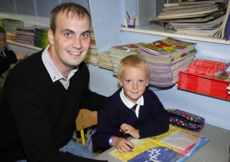 Six-year-old Megan Maher, who was diagnosed with an optic glioma tumour around two years ago, sits with her first-class teacher Dara O'Shea, at Gaelscoil Sairseal. Picture: Mike Cowhey