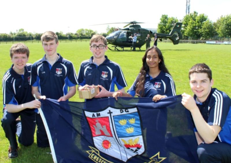 Up, up and away: Hugh Fitzgibbon, Evan Maloney, Niall Keating, Tayyaba Sheikh, and Chris Kelly, from Crescent College with the Air Corps helicopter waiting in the background this Wednesday. Picture: Michael Cowhey