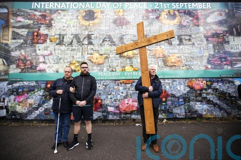 Communities unite to form human chain at peace wall to mark accord’s anniversary