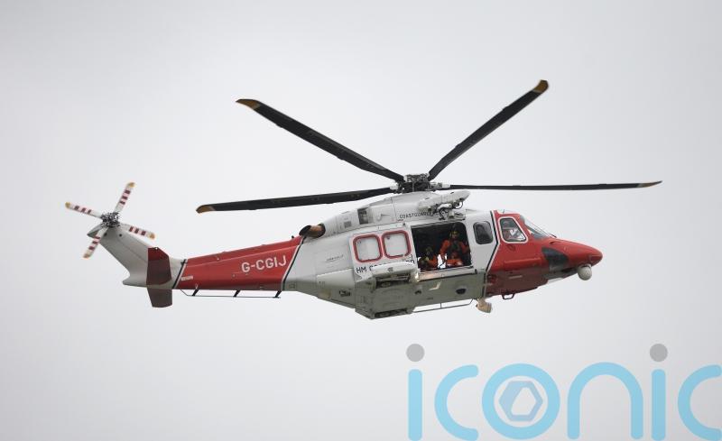 Search helicopter and lifeboats respond to overturned catamaran