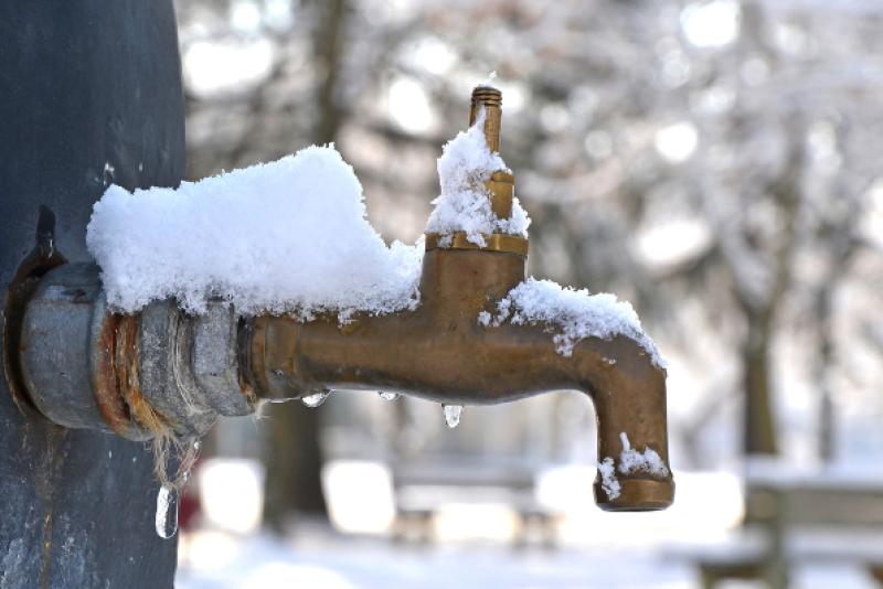 A public fountain with frozen tap