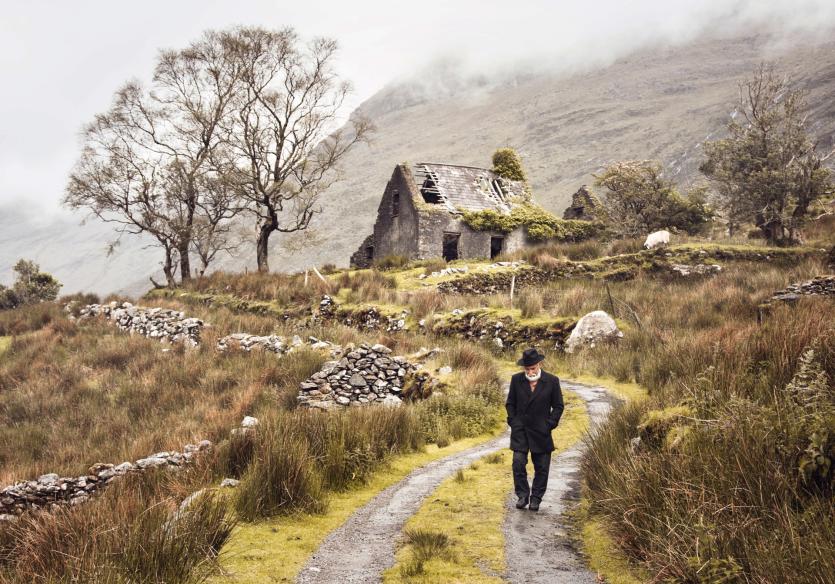 Man on the roadway with old house